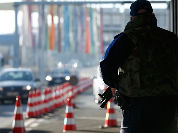 Funcionário armado vigia o posto alfandegário franco-suíço de Bardonnex, perto de Genebra, na sexta (11) (Foto: Reuters/Denis Balibouse)