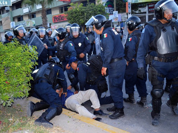 Um jornalista ferido é socorrido por policiais durante protesto em Chilpancingo, no estado mexicano de Guerrero, no domingo (14) (Foto: AP Photo/Alejandrino Gonzalez)