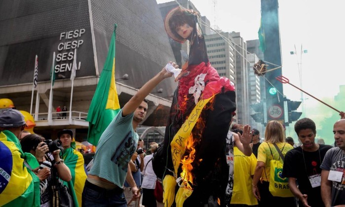 Depois de malharem os "Judas Dilma e Lula", os manifestantes atearam fogo aos bonecos na Avenida Paulista (Foto: Agência O Globo.)