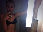 De top e shortinho, Miley Cyrus faz pose em banheiro
