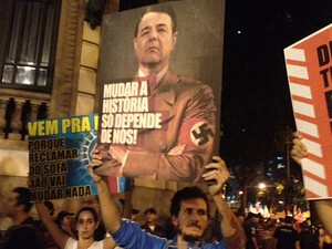No Rio de Janeiro, manifestante segura cartaz com imagem do governador do estado, Sérgio Cabral, vestido com uniforme nazista (Foto: Mariucha Machado/G1)