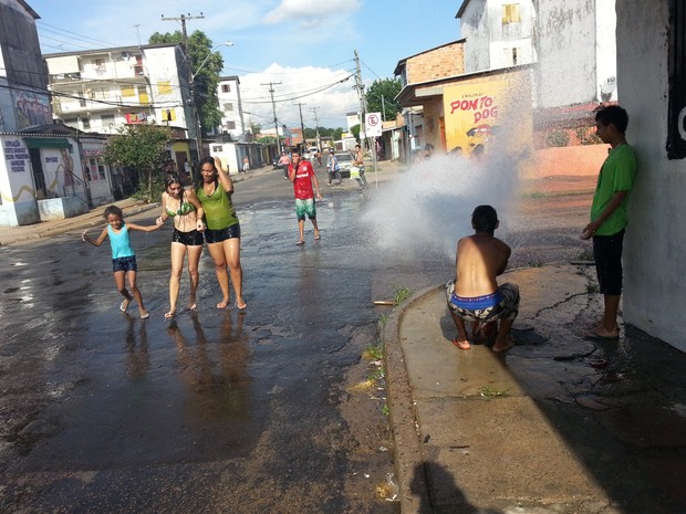 Na Cohab Cavalhada, adolescentes abriram um hidrante para se refrescar do calor (Foto: Giancarlo Barzi/RBS TV)