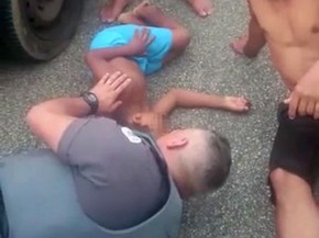 PM deita no chão para acalmar criança atropelada por caminhão (Foto: Divulgação / PM)