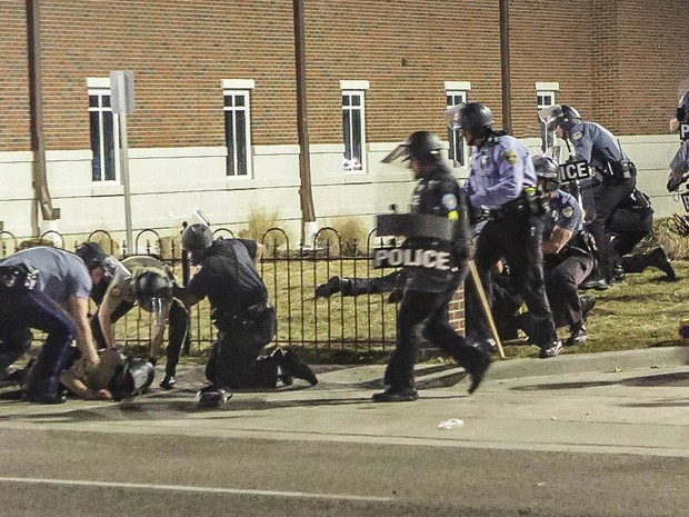 Policiais socorrem um colega atingido por um tiro em frente ao Departamento de Polícia de Ferguson, Missouri (EUA). Agentes da polícia chamaram o episódio de uma emboscada após meses de tensão entre manifestantes e as forças de segurança (Foto: awrence Bryant/St. Louis American/Reuters)