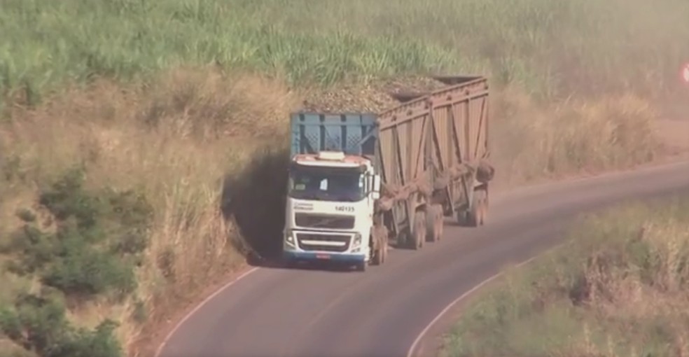 Caminhão trafega por rodovia com a lona na lateral do caminhão (Foto: Reprodução/TV TEM)