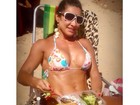 Scheila Carvalho posa de biquíni, comendo marmita na praia
