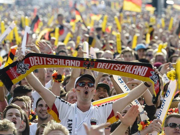 16/6 - Alemães celebram o gol de sua seleção contra Portugal, assistindo ao jogo da Copa do Mundo em telão armado próximo ao Portão de Brandemburgo, em Berlim (Foto: Clemens Bilan/AFP)