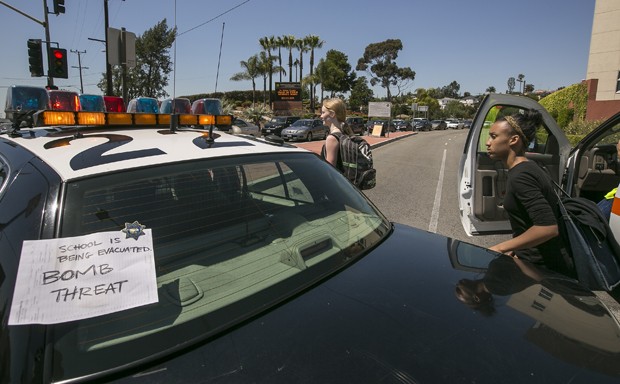 Aviso no carro de polícia indica a evacuação no campus (Foto: Damian Dovarganes/AP)