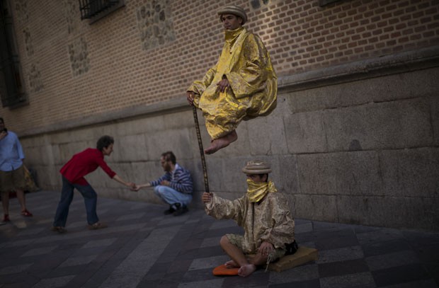 Homem é visto 'flutuando' sobre parceiro artista na capital espanhola (Foto: Emilio Morenatti/AP)