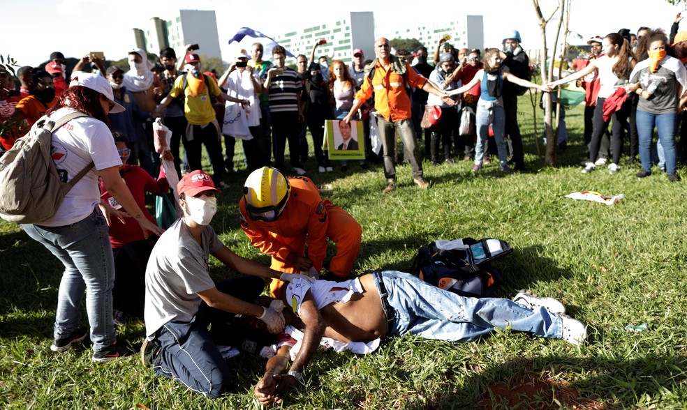 Um paramédico ajuda um homem ferido durante protesto contra o presidente Michel Temer, em Brasília  (Foto: Ueslei Marcelino/Reuters)