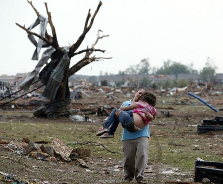 Uma mulher carrega sua criança por uma área perto da escola Plaza Towers, destruída pelo tornado em Moore, Oklahoma (Foto: Sue Ogrocki/AP)