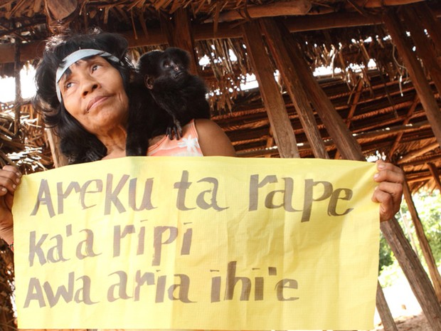 Indígena segura faixa em que está escrito 'nós existimos!' no idioma dos Awa-Guajá. O grupo, considerado um dos mais ameaçados do munso, está localizado em uma região do Maranhão muito pressionada pelo desmatamento (Foto: Eliza Capai/Greenpeace)