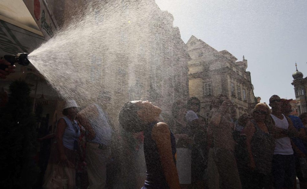 Menino se refresca no centro de Praga para enfrentar onda de calor incomum que atingiu a Europa (Foto: Petr David Josek/Reuters)