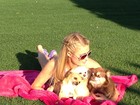 Paris Hilton relaxa sobre a grama com as suas três cachorrinhas