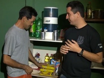 Mário Ferreira Lima mostra compras doadas por policiais e o agente Ricardo Machado (Foto: TV Globo/Reprodução)