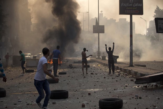 Manifestantes pró e contra a Irmandade Muçulmana se enfrentam neste domingo (6) nas ruas do Cairo (Foto: AFP)