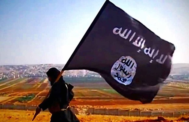 Militante carrega bandeira do Estado Islâmico (EI) : grupo coordena e lança ações terroristas (Foto: Reprodução/YouTube)