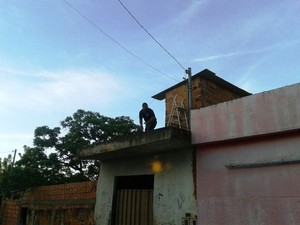 Policial faz buscas na casa de um dos investigados (Foto: Michelly Oda / G1)