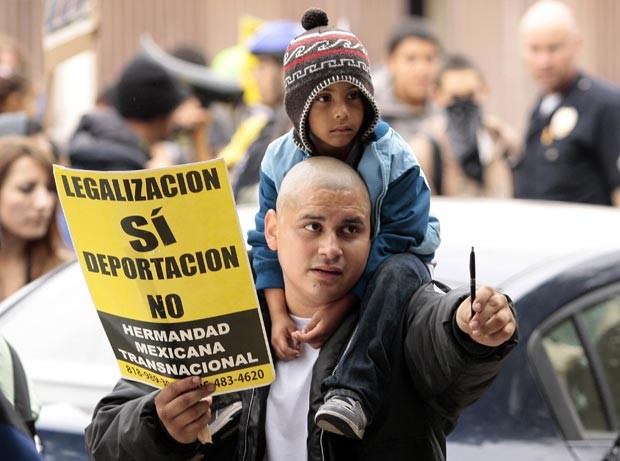 Manifestante protesta contra a política de imigração do governo dos EUA durante as festas de Primeiro de Maio em Los Angeles, na Califórnia (Foto: AFP)