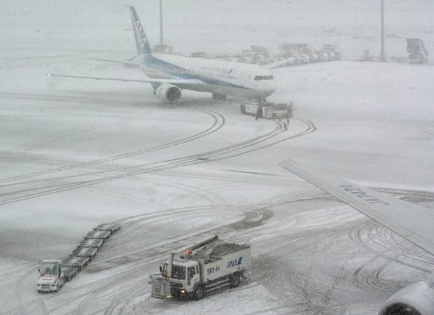  Jato japonês no aeroporto de Tóquio, coberto de neve neste sábado (Foto: Kazuhiro Nogi/AFP)