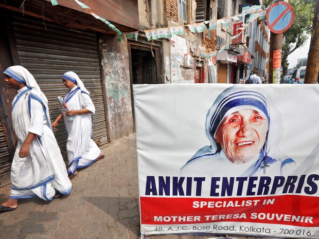 Missionárias da Caridade passam por um cartaz de Madre Teresa em Calcutá, Índia, neste sábado (3) (Foto: Reuters/Rupak De Chowdhuri)