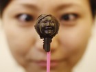 Japonesa olha pirulito de chocolate com imagem do próprio rosto