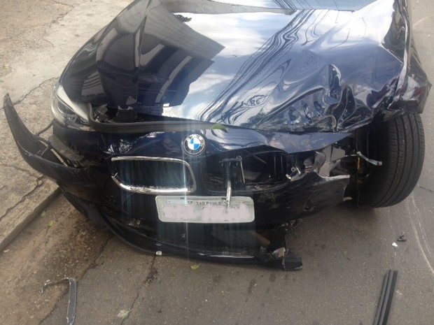BMW ficou danificada após motorista colidir em viatura da polícia  (Foto: Lívia Machado/G1)