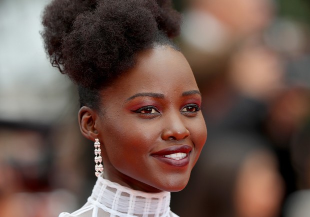 O make de Lupita Nyong'o tem pele bem feita, sombra vermelha, delineador estilo gatinho e lábios vinho (Foto: Getty Images) O make de Lupita Nyong'o tem pele bem feita, sombra vermelha, delineador estilo gatinho e lábios vinho (Foto: Getty Images)