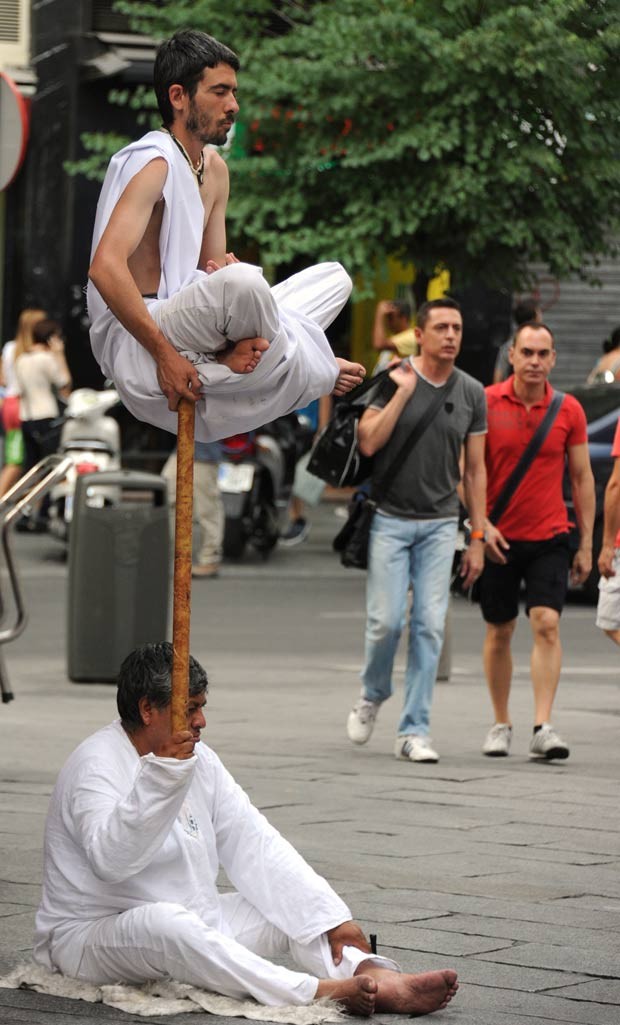 Um artista de rua parecia levitar durante um apresentação na terça-feira (26) em uma praça em Madri, na Espanha. (Foto: Dominique Faget/AFP)