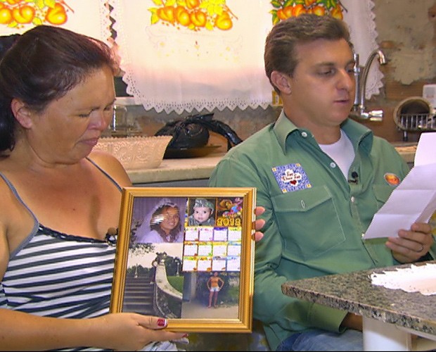 Dona Neusa se emociona com fotos da filha nas mãos (Foto: Caldeirão do Huck/TV Globo)