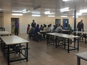 Haitianos se re&uacute;nem no refeit&oacute;rio, local onde preparam a pr&oacute;pria comida (Foto: Felipe Truda/G1)