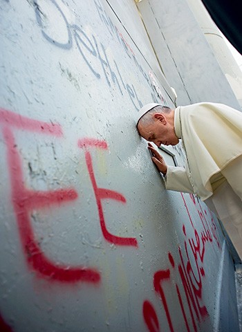 O OUTRO MURO Um dia antes  de ir ao Muro das Lamentações, Francisco rezou na barreira erguida por Israel. Ele fez um pedido de paz (Foto: Osservatore Romano/AP)