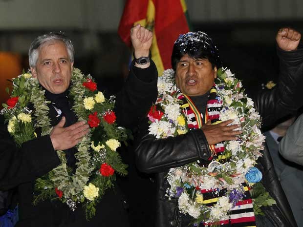 Evo Morales e o vice-presidente Alvaro Garcia Linera cantam o hino nacional da Bolívia no Aeroporto de El Alto, nos arredores de La Paz. (Foto: David Mercado / Reuters)