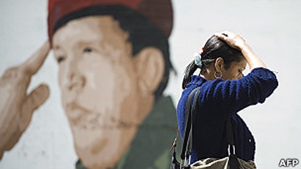 Mulher passa diante de painel com figura de Chávez em Caracas (Foto: AFP) Mulher passa diante de painel com figura de Chávez em Caracas (Foto: AFP)