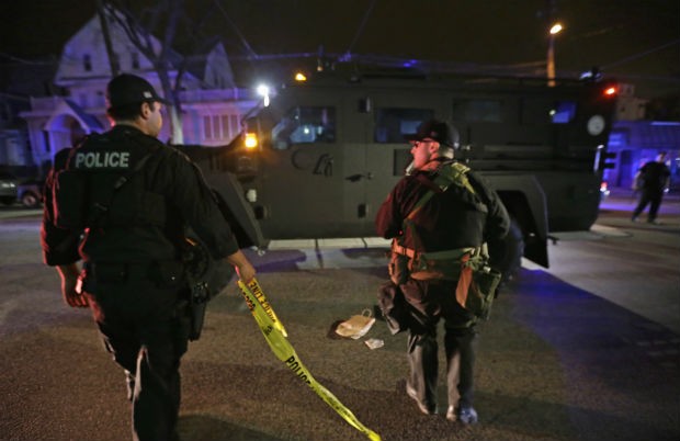 Policiais procuram o segundo suspeito de causar as explosões durante a Maratona de Boston. O primeiro suspeito foi morto (Foto: Julio Cortez/AP)