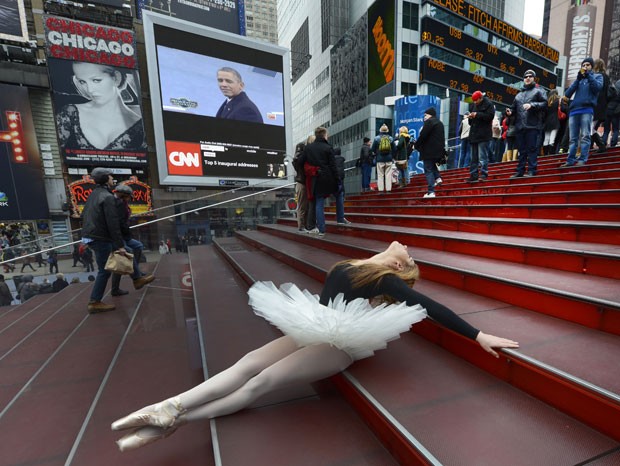 Em Nova York, enquanto a posse de Obama é transmitida ao vivo por um telão, uma bailarina parece não ligar muito e faz pose na escadaria montada no meio da Times Square. (Foto: Timothy A. Clary/AFP)