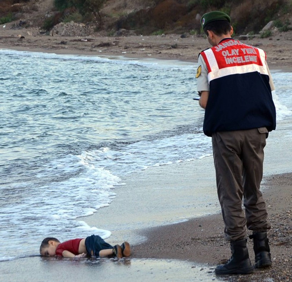 Policial paramilitar turco investiga o local onde apareceu o corpo de uma criança imigrante numa praia de Bodrum, na Turquia (Foto: AP Photo)