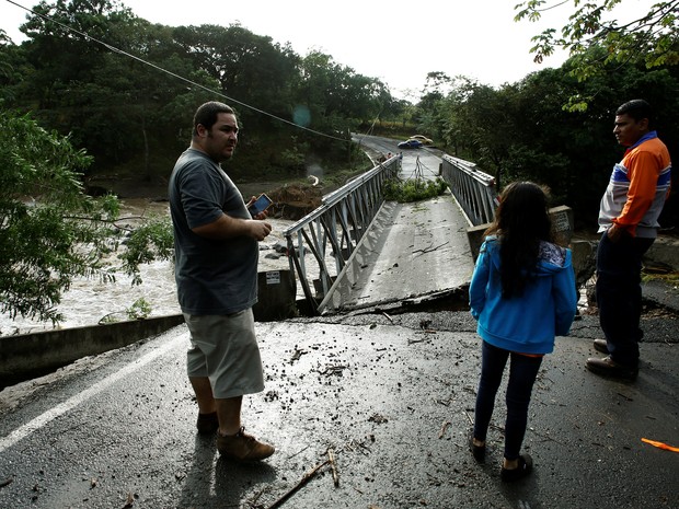 Pessoas olham para ponte destruída pelo furacão Otto, na Costa Rica (Foto: Juan Carlos Ulate/Reuters)