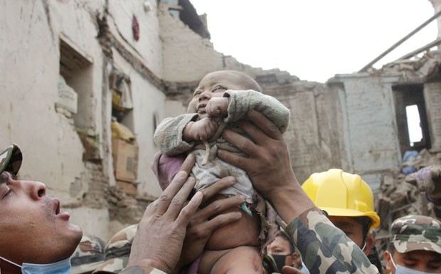 Foto de domingo (26) mostra o bebê Sonit Awal sendo retirado dos escombros de sua casa após ficar 22 horas soterrado no Nepal (Foto: Amul Thapa/Kathmandu Today via AP)