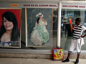 Fotógrafo promove seu trabalho na vitrine de uma loja para pequenos negócios privados em Havana (Foto: Alejandro Ernesto/EFE)