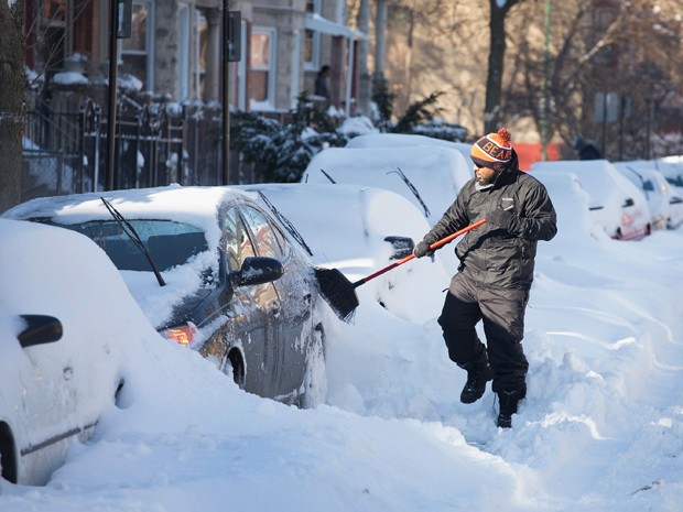 Marcus Neris tira neve que cobre seu carro na segunda-feira (2), em Chicago, Illinois (Foto: Scott Olson/Getty Images/AFP)