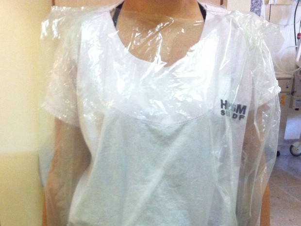 Funcionária vestindo saco plástico como improviso para a falta de capote no Hospital de Santa Maria (Foto: Arquivo pessoal/Divulgação)