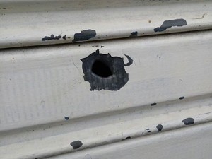 Marca do tiro na porta de uma loja em Conde, na Bahia (Foto: Arquivo pessoal)
