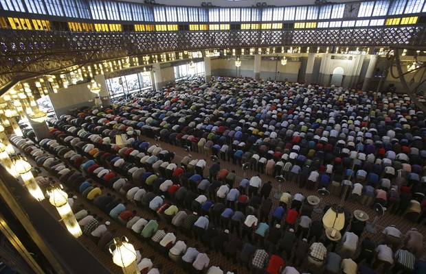 Em uma mesquite de Kuala Lumpur, na Malásia, muçulmanos dedicam oração às vítimas do avião da Malaysia Airlines que está desaparecido desde o dia 8 de março (Foto: AP Photo/Aaron Favila)