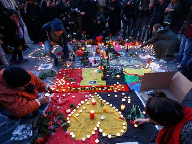 Pessoas deixam flores e velas em um memorial às vítimas dos ataques em Bruxelas, na Bélgica. Explosões atingiram o aeroporto de Zaventem e uma estação de metrô deixando ao menos 34 mortos e 200 feridos (Foto: Charles Platiau/Reuters)