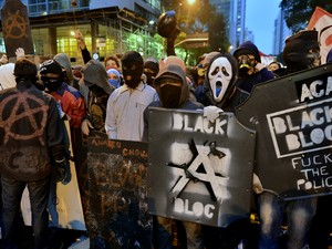 Mais de 50 black blocs, todos mascarados, acabam de chegar à manifestação, com gritos de 'deixa passar, a revolta popular'. (Foto: Christophe Simon/AFP)