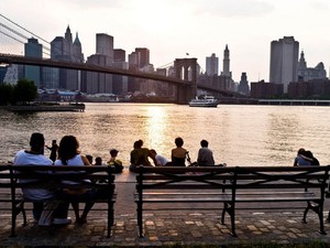 Visitantes observam o East River e a vista de Manhattan do Brooklyn Bridge Park (Foto: Michel Setboun / Photononstop/ AFP)
