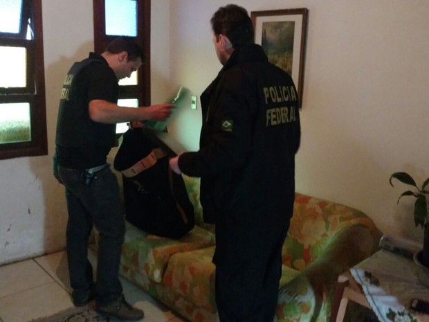 Policiais federais apreendem documentos na casa de suspeito no Rio Grande do Sul durante operação contra fraude em urnas eletrônicas (Foto: Polícia Federal/Divulgação)