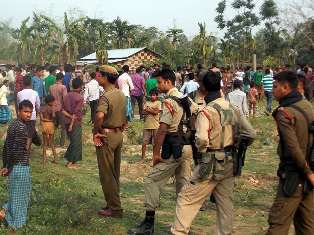Guardas indianos são fotografados enquanto passam em meio a moradores de um vilarejo em Kokrajhar, no estado de Assam, nesta sexta-feira (2) (Foto: AFP Photo/STR)