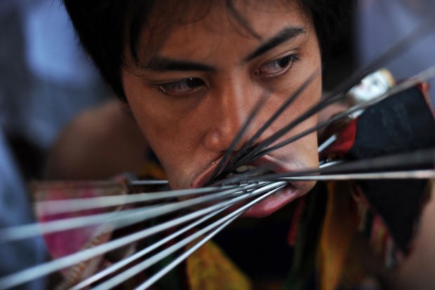 Devotos furam bochechas com metal em ritual de purificação na Tailândia (Foto: Christophe Archambault/AFP)